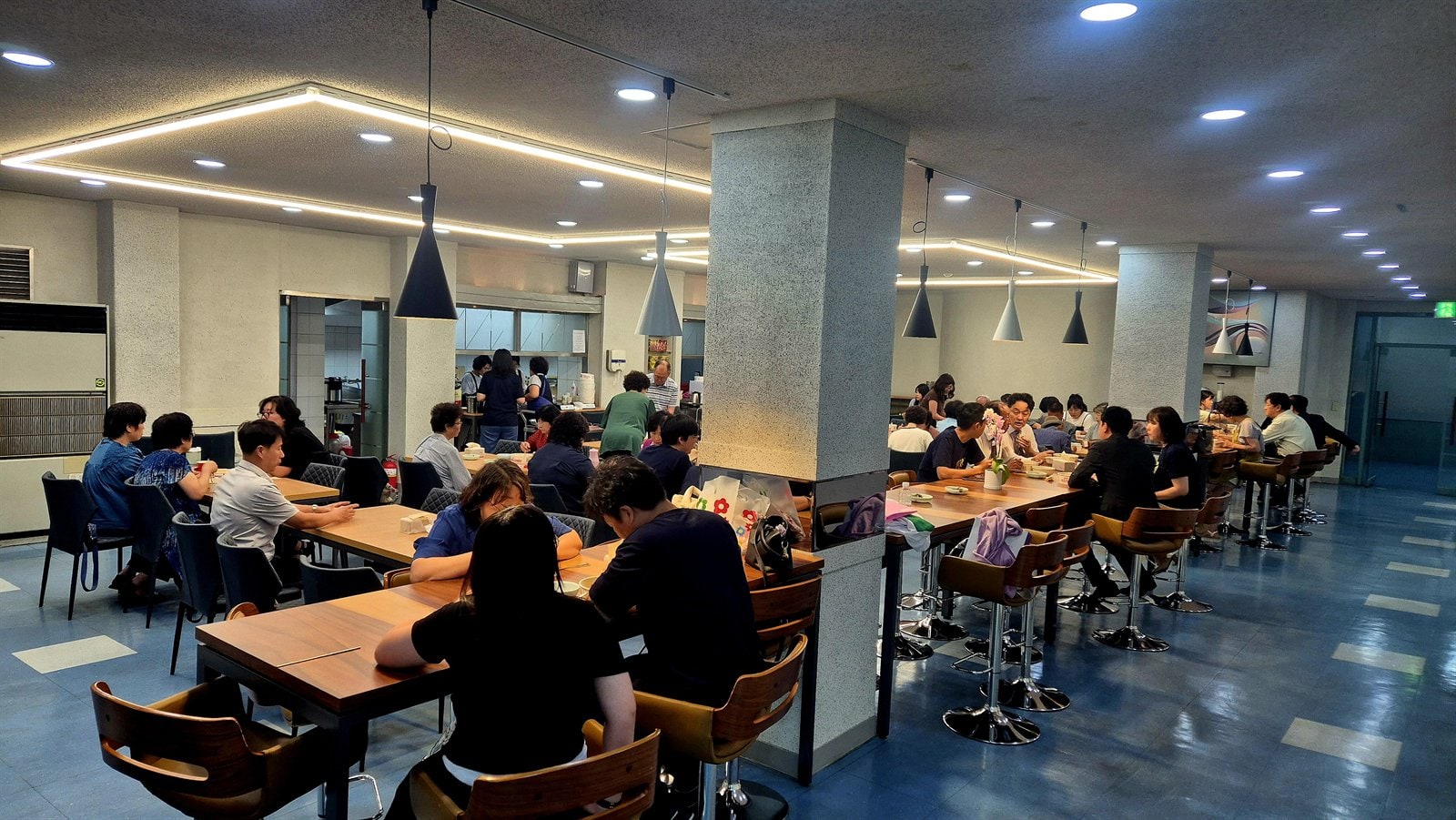 식탁마다 둘러앉아 이야기를 나누는 식당 안 모습